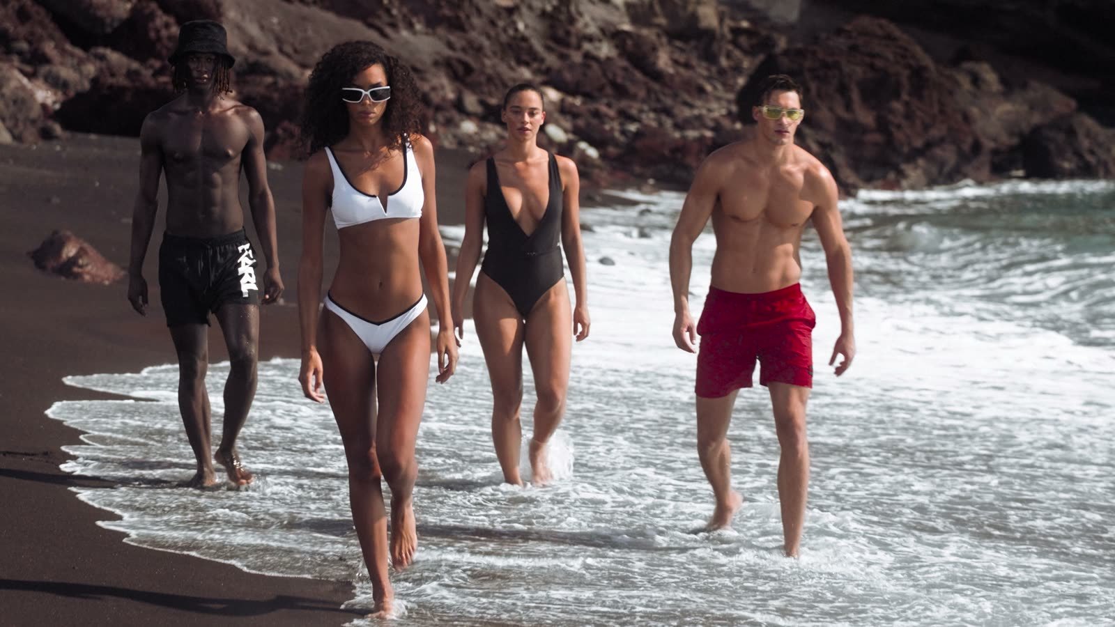 Commercial music composer: four models walking along the surf in a Karl Lagerfeld campaign video